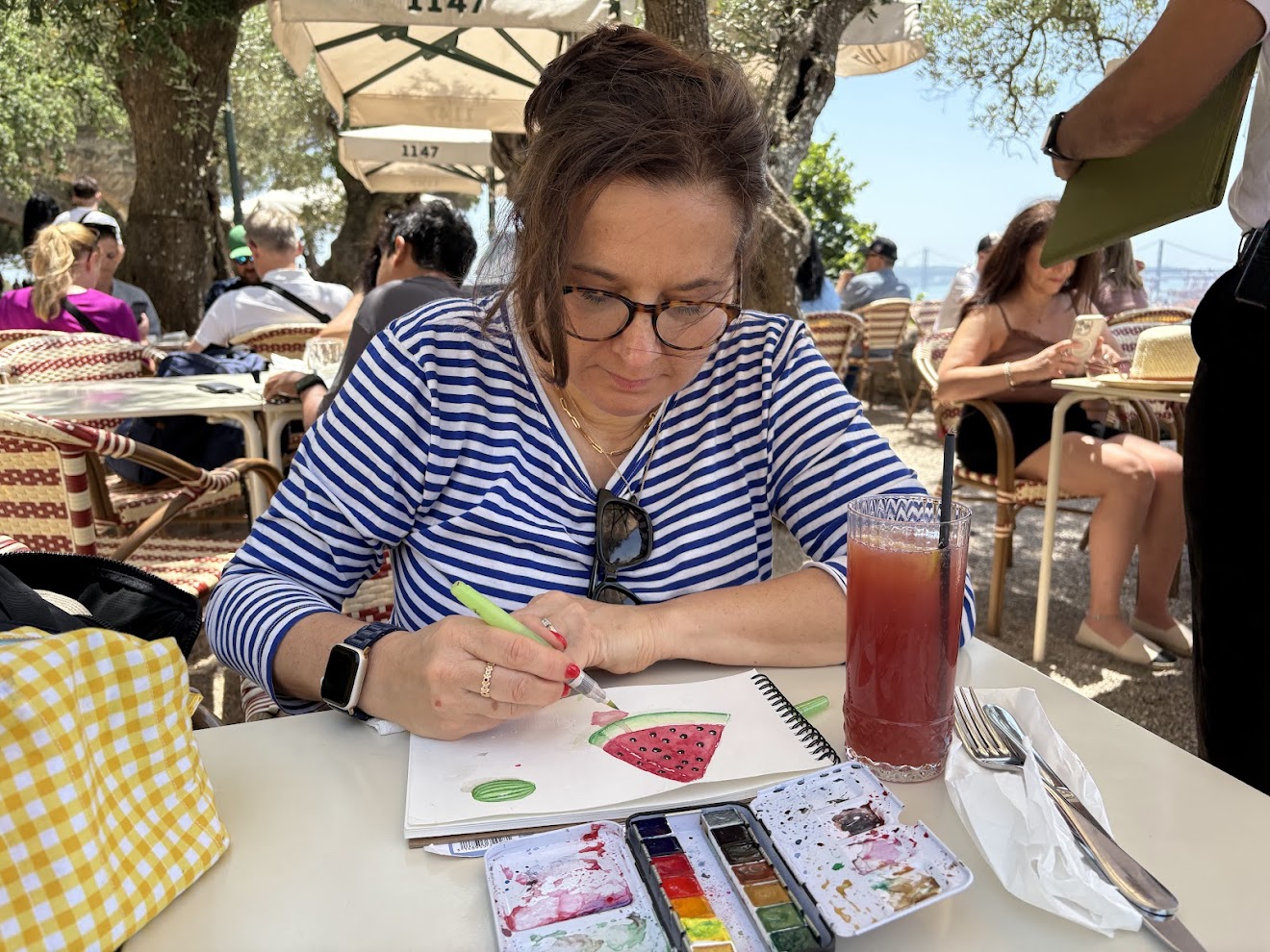 Amy Traverso painting a watercolor illustration at a cafe table